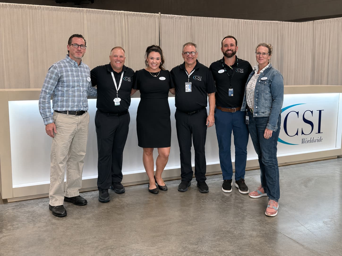 CSI Worldwide team at a branded service counter on the show floor