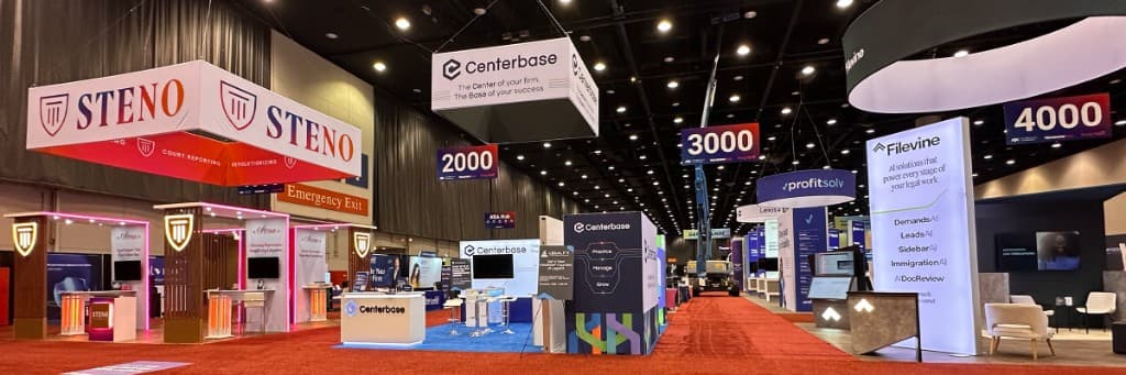 Trade show floor with exhibitor booths and hanging signs during active show operations