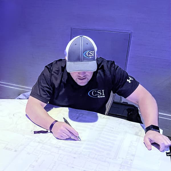 CSI team member marking a show floor plan on site